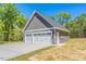 Detached two-car garage with white doors, set on a concrete pad in a wooded backyard at 193 Jim S Rd, Cameron, NC 28326