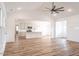 Open-concept living room with vaulted ceiling, ceiling fan, hardwood floors, and connected kitchen at 193 Jim S Rd, Cameron, NC 28326