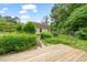 Spacious backyard with a deck, lush garden, and stone pathway to home at 20 Timberlyne Rd, Chapel Hill, NC 27514