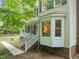 Charming home exterior with tan siding, green shutters, brick foundation, and a bay window at 20 Timberlyne Rd, Chapel Hill, NC 27514
