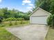Exterior shot of a detached garage and concrete driveway, surrounded by grass and mature landscaping at 20 Timberlyne Rd, Chapel Hill, NC 27514