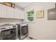 Bright laundry room with modern washer and dryer, white cabinets, and natural light at 20 Timberlyne Rd, Chapel Hill, NC 27514