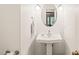 Charming powder room features a pedestal sink, decorative mirror, and neutral finishes at 20 Timberlyne Rd, Chapel Hill, NC 27514