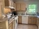 Efficient kitchen layout with white appliances, natural wood cabinets and countertops, and natural light at 2000 University Woods Rd # 203, Raleigh, NC 27603