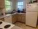 Bright kitchen features white appliances, natural wood cabinets, and a stainless steel sink with natural light at 2000 University Woods Rd # 203, Raleigh, NC 27603