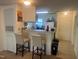 Eat-in kitchen with breakfast bar and stylish barstools with white cabinets and appliances at 2000 University Woods Rd # 203, Raleigh, NC 27603