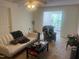 Cozy living room featuring neutral carpeting, sofa and view of the sunroom at 2000 University Woods Rd # 203, Raleigh, NC 27603