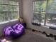 Bright sunroom featuring a purple beanbag chair, windows, and weights at 2000 University Woods Rd # 203, Raleigh, NC 27603