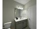 Bright bathroom featuring a gray vanity with quartz countertop, a mirror and a white door at 202 S Pearl St, Princeton, NC 27569