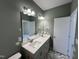 Bathroom featuring double sinks, modern lighting, and gray cabinets at 202 S Pearl St, Princeton, NC 27569