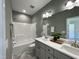 Bathroom featuring a shower-tub, double vanity, and herringbone floors at 202 S Pearl St, Princeton, NC 27569