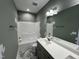 Bathroom with a modern vanity, well-lit mirror, tile flooring and a shower-tub combination at 202 S Pearl St, Princeton, NC 27569