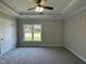 Spacious carpeted bedroom with a window and ceiling fan, offering a comfortable retreat at 202 S Pearl St, Princeton, NC 27569