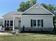 Charming single-story home with stone accents, a covered porch, manicured lawn and craftsman details at 202 S Pearl St, Princeton, NC 27569