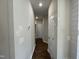 Hallway with hardwood floors and neutral-colored walls offers a seamless flow between rooms at 202 S Pearl St, Princeton, NC 27569