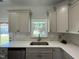 Well lit kitchen sink with a window providing natural light and stainless steal appliances at 202 S Pearl St, Princeton, NC 27569