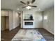 Open-concept living room with a modern fireplace, ceiling fan, and hardwood floors at 202 S Pearl St, Princeton, NC 27569