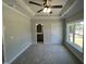 Inviting main bedroom with tray ceiling, ceiling fan, an ensuite bathroom, and large window at 202 S Pearl St, Princeton, NC 27569
