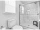 Clean white bathroom with a tiled glass shower, toilet, and window for natural light at 209 Bradley Dr, Benson, NC 27504