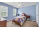 Cozy bedroom features two windows, ceiling fan, and a colorful bedspread on a wooden frame at 209 Bradley Dr, Benson, NC 27504