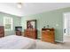 Bright bedroom with green walls and carpet has two dressers and a window view of outside at 209 Bradley Dr, Benson, NC 27504
