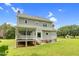 Back exterior of the home features a charming covered porch, deck, and spacious backyard at 209 Bradley Dr, Benson, NC 27504