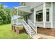 Charming back porch with stairs leading to a lush green lawn and landscaped yard at 209 Bradley Dr, Benson, NC 27504