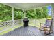 Cozy covered porch with grill and rocking chair overlooking a lush backyard at 209 Bradley Dr, Benson, NC 27504