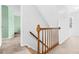 Upstairs staircase with wood banister leading to carpeted hallway at 209 Bradley Dr, Benson, NC 27504