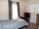 Bedroom with a queen bed, TV on a dresser and large window with gray curtains at 220 Howard St, Burlington, NC 27217