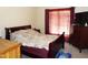 Bedroom with a bed, dresser, and dark red curtains allowing privacy at 220 Howard St, Burlington, NC 27217