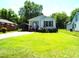Cozy single-story home with light siding, a welcoming front porch, and a large lawn at 220 Howard St, Burlington, NC 27217