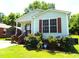 Attractive single-story home with light siding, front porch, and blossoming bushes at 220 Howard St, Burlington, NC 27217
