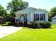 Quaint single-story home featuring light siding, a cozy front porch, and convenient covered parking at 220 Howard St, Burlington, NC 27217