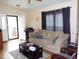 Cozy living room featuring a comfortable sofa, front entry access, and hardwood floors at 220 Howard St, Burlington, NC 27217
