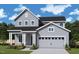 Charming two-story home with gray siding, black roof, an attached two car garage and a welcoming front porch at 25 Cozy Hvn, Fuquay Varina, NC 27526