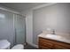 Modest bathroom with a sliding glass door shower, commode, and wooden sink vanity at 306 W Main St, Pine Level, NC 27568