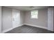 A simple room has grey walls, updated flooring and a white entry door and closet at 306 W Main St, Pine Level, NC 27568
