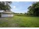 View of a detached one-car garage, green grass, and gravel driveway at 306 W Main St, Pine Level, NC 27568