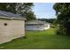 View of detached garage with matching paint and well-kept lawn at 306 W Main St, Pine Level, NC 27568