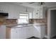 Kitchen featuring white cabinetry, stainless sink, and brick backsplash at 306 W Main St, Pine Level, NC 27568