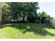 Spacious backyard with lush green grass, mature trees, and a wooden fence at 328 Mccarthy Dr, Clayton, NC 27527