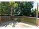 Backyard deck surrounded by a wooden railing, with a large grassy backyard and mature trees at 328 Mccarthy Dr, Clayton, NC 27527