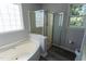 Bright bathroom with a glass-enclosed shower, soaking tub, and a large window at 328 Mccarthy Dr, Clayton, NC 27527
