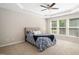 Bright bedroom features a tray ceiling, ceiling fan and natural light from the windows at 3661 Manifest Pl, Cary, NC 27519