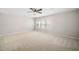Bedroom with neutral walls and carpeting, large window, and a ceiling fan at 3661 Manifest Pl, Cary, NC 27519