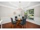 Elegant dining room featuring hardwood floors, a glass-top table, and wainscoting at 3661 Manifest Pl, Cary, NC 27519