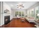 Bright living room featuring hardwood floors, fireplace, built-in shelving, and plantation shutters at 3661 Manifest Pl, Cary, NC 27519