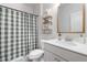 Bathroom with plaid shower curtain, white vanity and sink with shelf above the toilet at 41 Liam Dr, Broadway, NC 27505