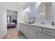 Bathroom with double vanity, blue wallpaper, gray cabinets and wood-look floor at 41 Liam Dr, Broadway, NC 27505